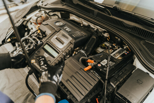 Mechanic performing diagnostic test on car battery during mobile car battery replacement in Sydney. Mechanic performing diagnostic test on car battery during mobile car battery replacement in Sydney.