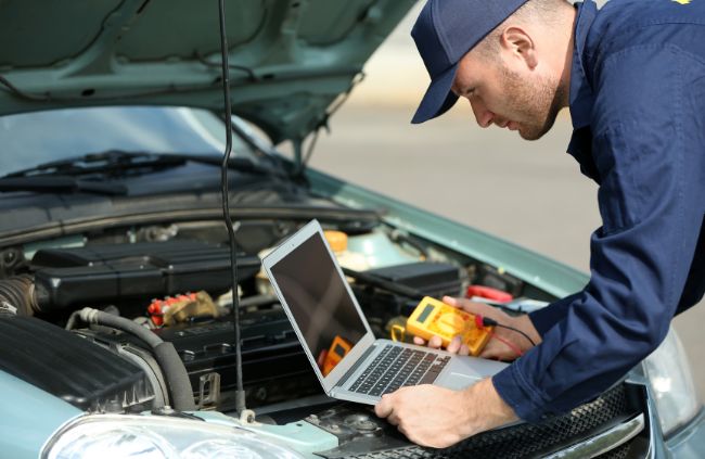 True Blue Mobile Mechanics technician performing car diagnostics using laptop and tools during mobile car repair in Sydney True Blue Mobile Mechanics technician performing car diagnostics using laptop and tools during mobile car repair in Sydney